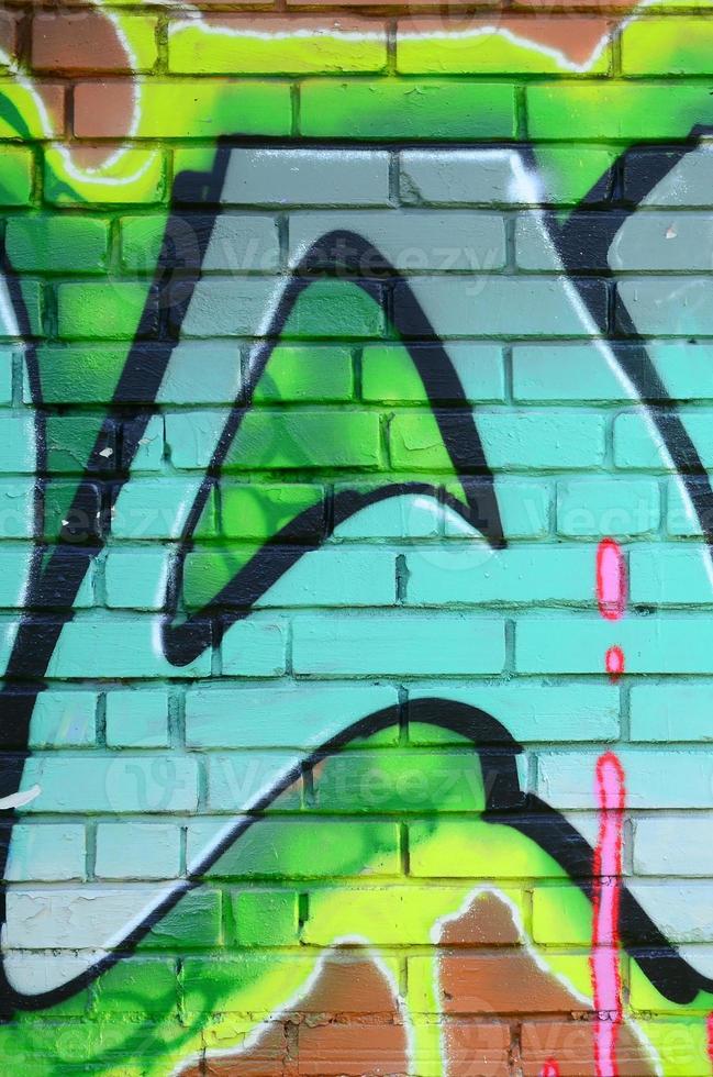 Fragment of graffiti drawings. The old wall decorated with paint stains in the style of street art culture. Colored background texture in green tones photo