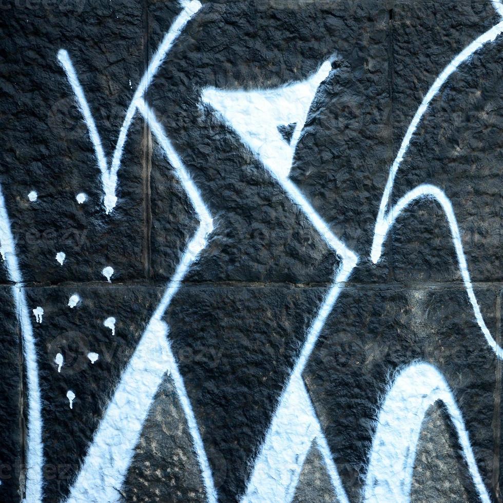 Fragment of graffiti drawings. The old wall decorated with paint stains in the style of street art culture. Colored background texture photo