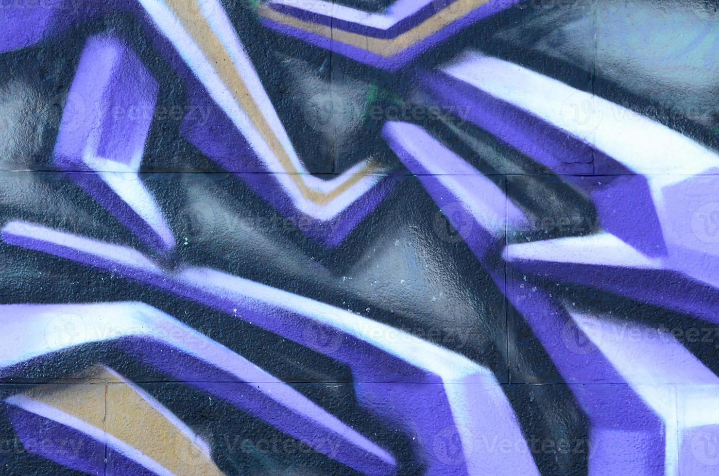 Fragment of graffiti drawings. The old wall decorated with paint stains in the style of street art culture. Colored background texture in purple tones photo