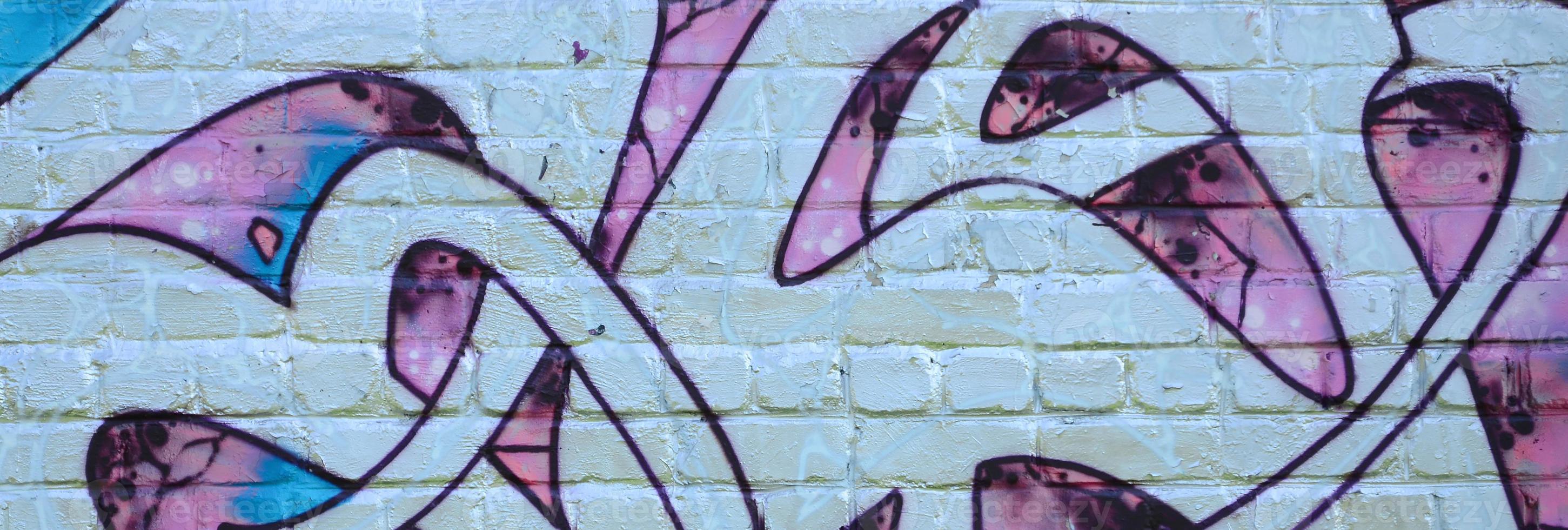 Fragment of graffiti drawings. The old wall decorated with paint stains in the style of street art culture. Colored background texture in purple tones photo