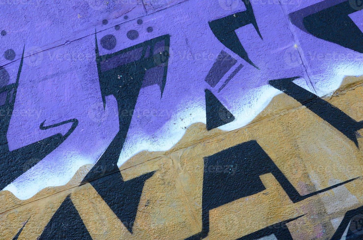 Fragment of graffiti drawings. The old wall decorated with paint stains in the style of street art culture. Colored background texture in purple tones photo