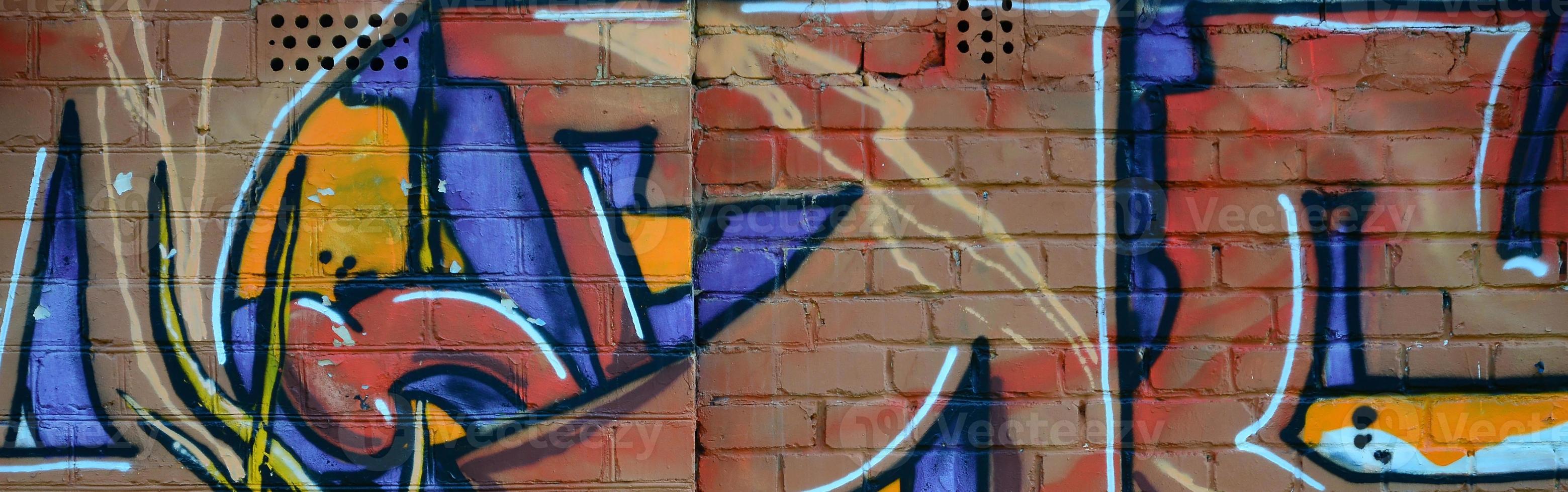 Fragment of graffiti drawings. The old wall decorated with paint stains in the style of street art culture. Colored background texture in warm tones photo