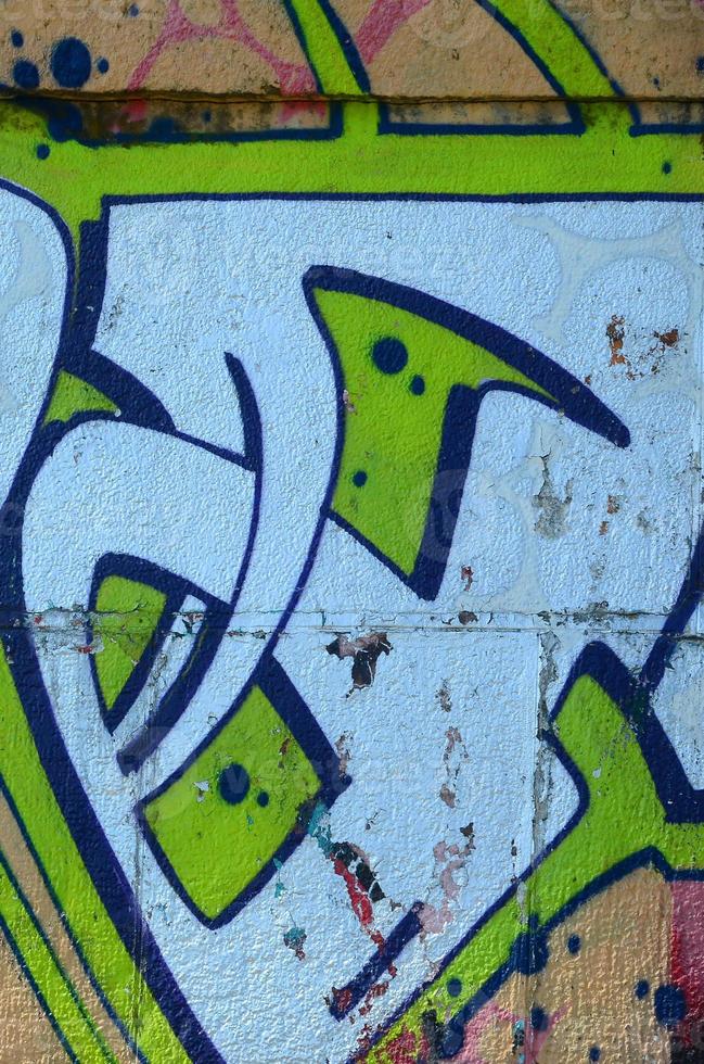 fragmento de dibujos de graffiti. la antigua muralla decorada con manchas de pintura al estilo de la cultura del arte callejero. textura de fondo coloreada en tonos verdes foto