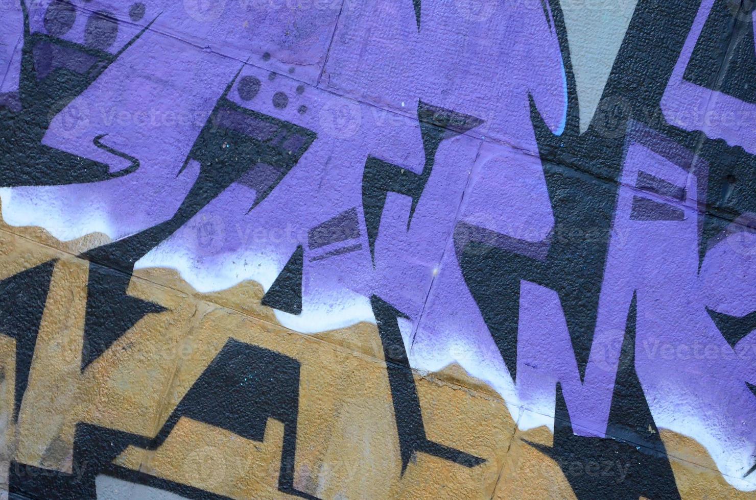 Fragment of graffiti drawings. The old wall decorated with paint stains in the style of street art culture. Colored background texture in purple tones photo