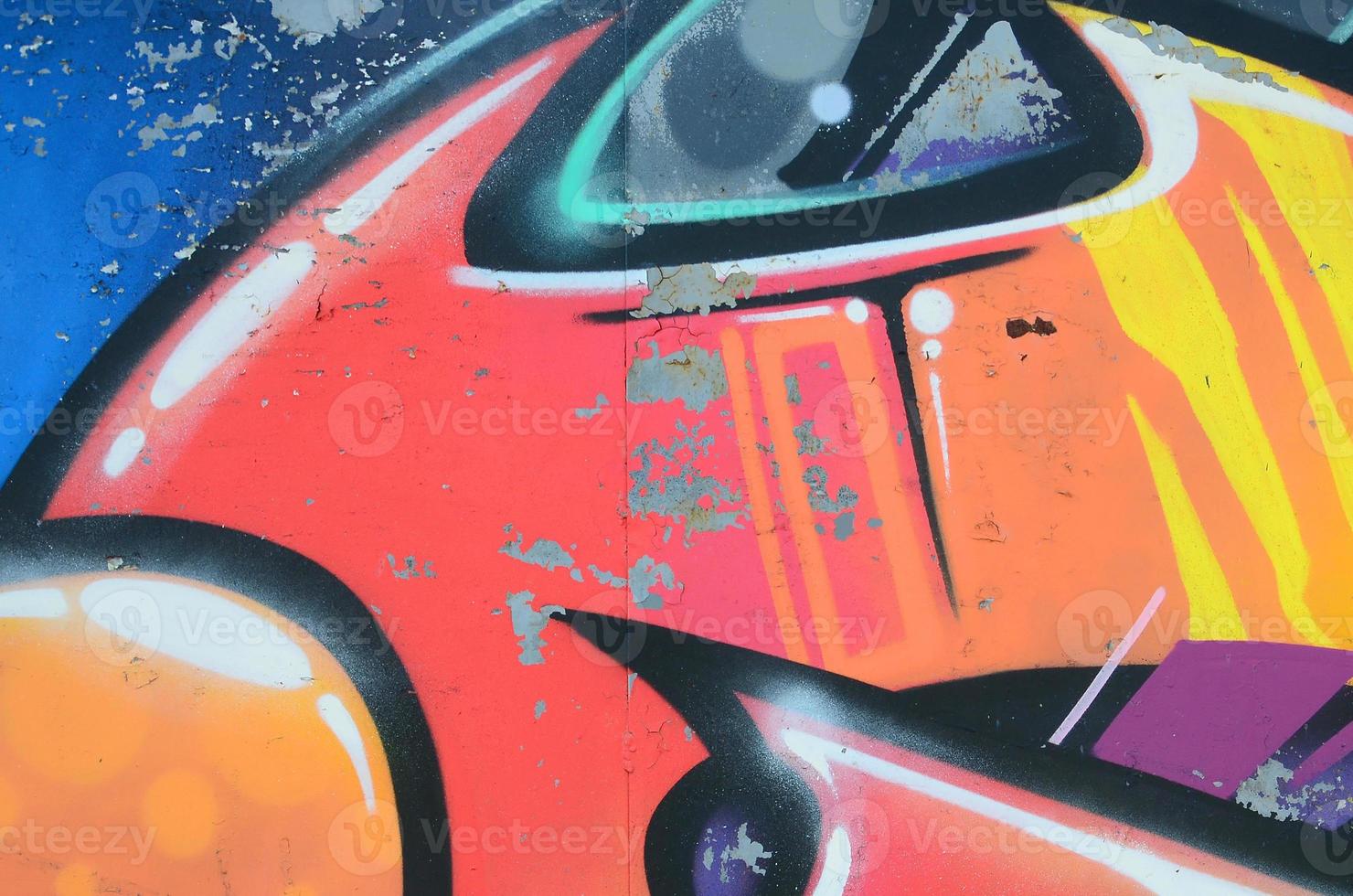 Fragment of graffiti drawings. The old wall decorated with paint stains in the style of street art culture. Colored background texture in warm tones photo