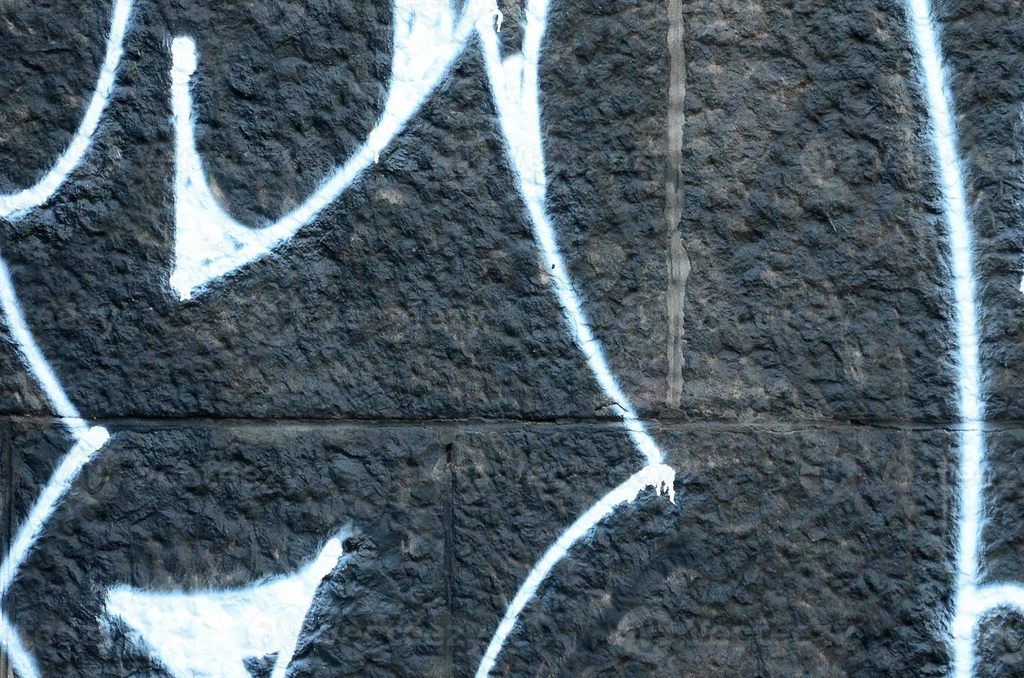 Fragment of graffiti drawings. The old wall decorated with paint stains in the style of street art culture. Colored background texture photo