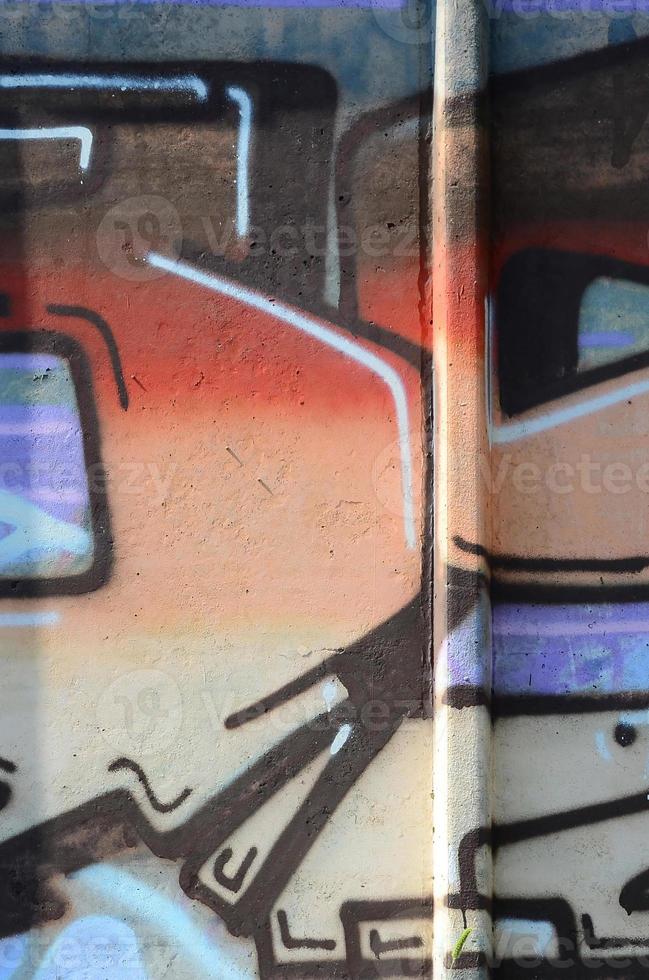 Fragment of graffiti drawings. The old wall decorated with paint stains in the style of street art culture. Colored background texture in warm tones photo