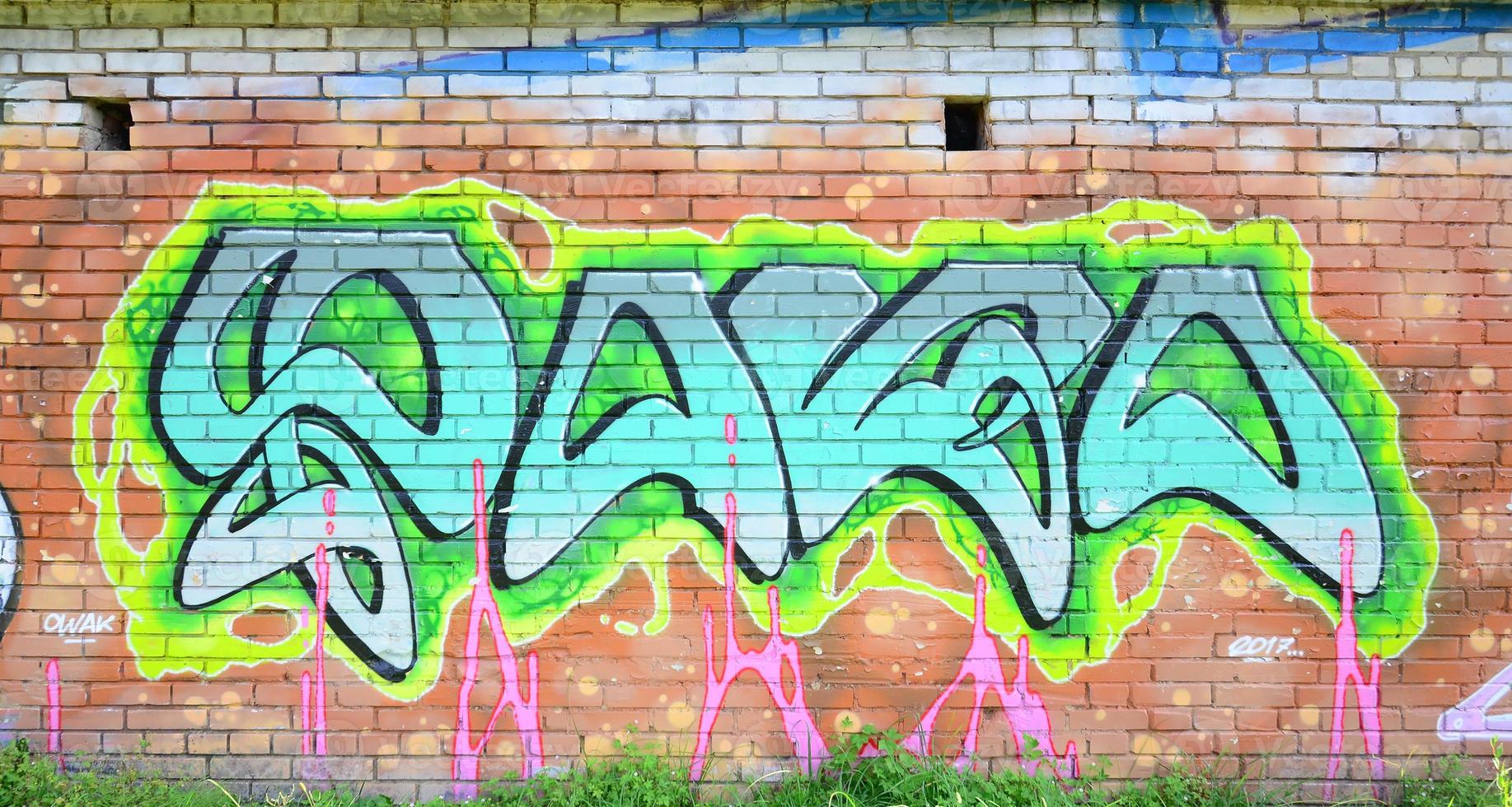 fragmento de dibujos de graffiti. la antigua muralla decorada con manchas de pintura al estilo de la cultura del arte callejero. textura de fondo coloreada en tonos verdes foto