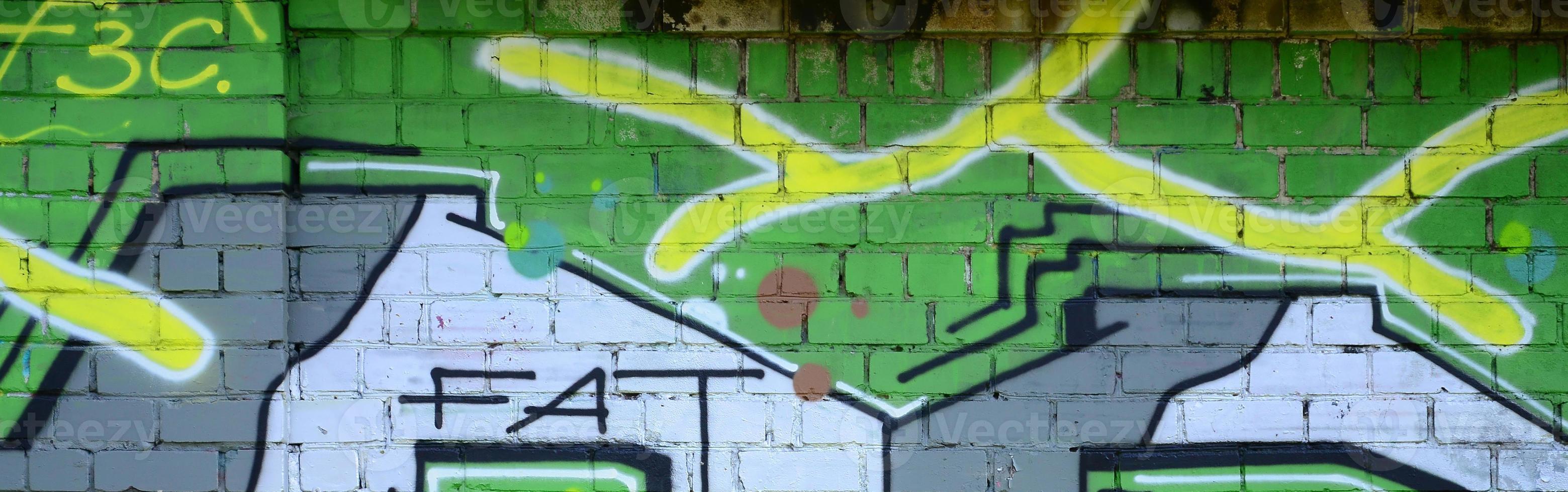 fragmento de dibujos de graffiti. la antigua muralla decorada con manchas de pintura al estilo de la cultura del arte callejero. textura de fondo coloreada en tonos verdes foto