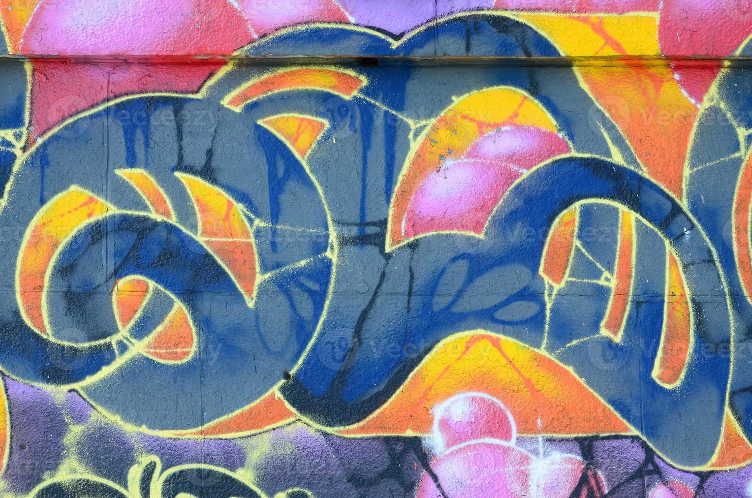 Fragment of graffiti drawings. The old wall decorated with paint stains in the style of street art culture. Colored background texture in warm tones photo