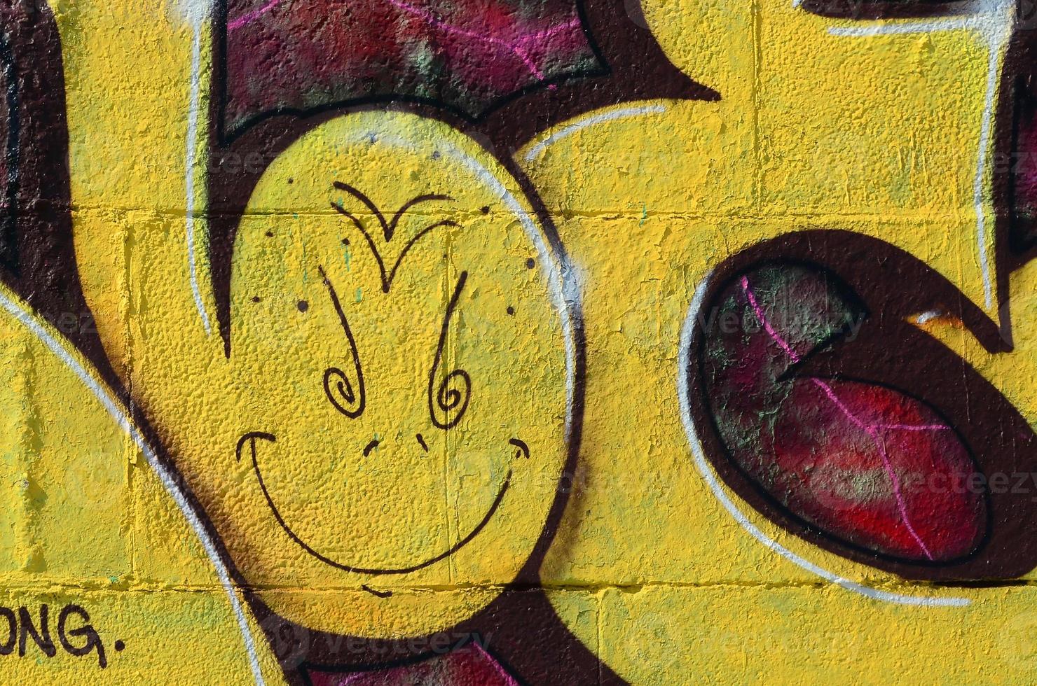 Fragment of graffiti drawings. The old wall decorated with paint stains in the style of street art culture. Colored background texture in warm tones photo