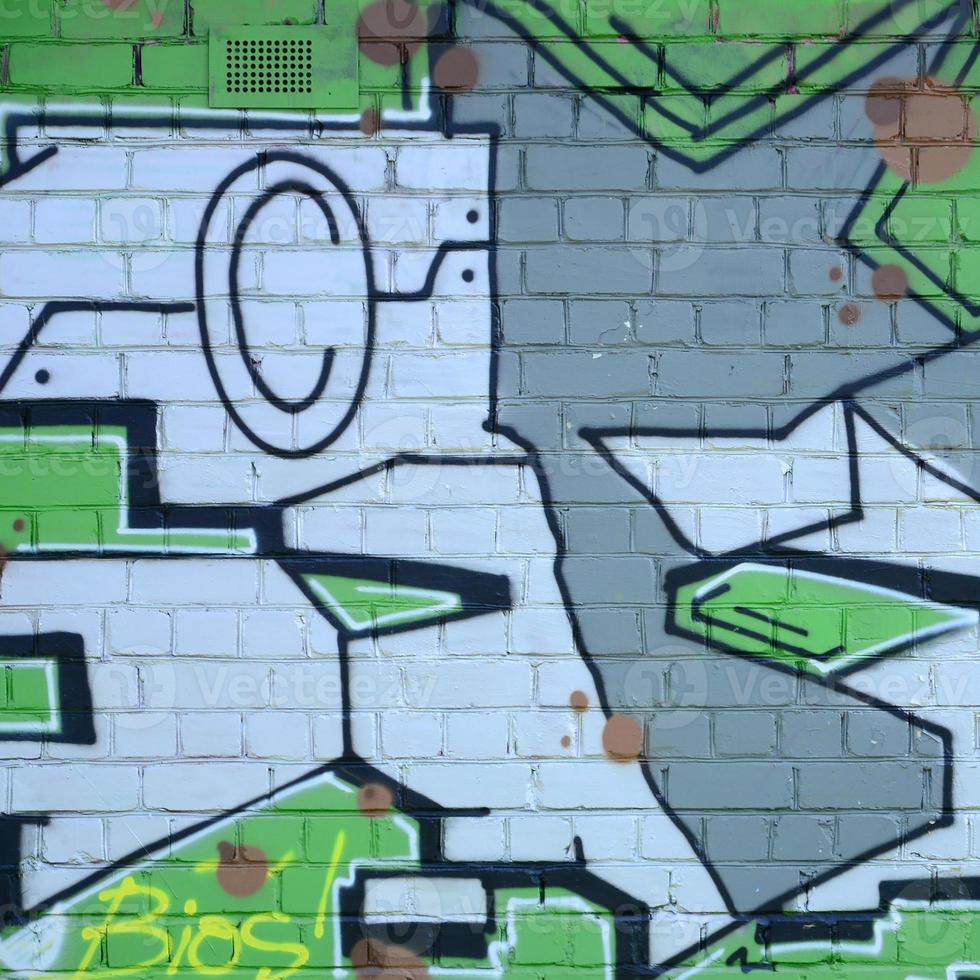 Fragment of graffiti drawings. The old wall decorated with paint stains in the style of street art culture. Colored background texture in green tones photo