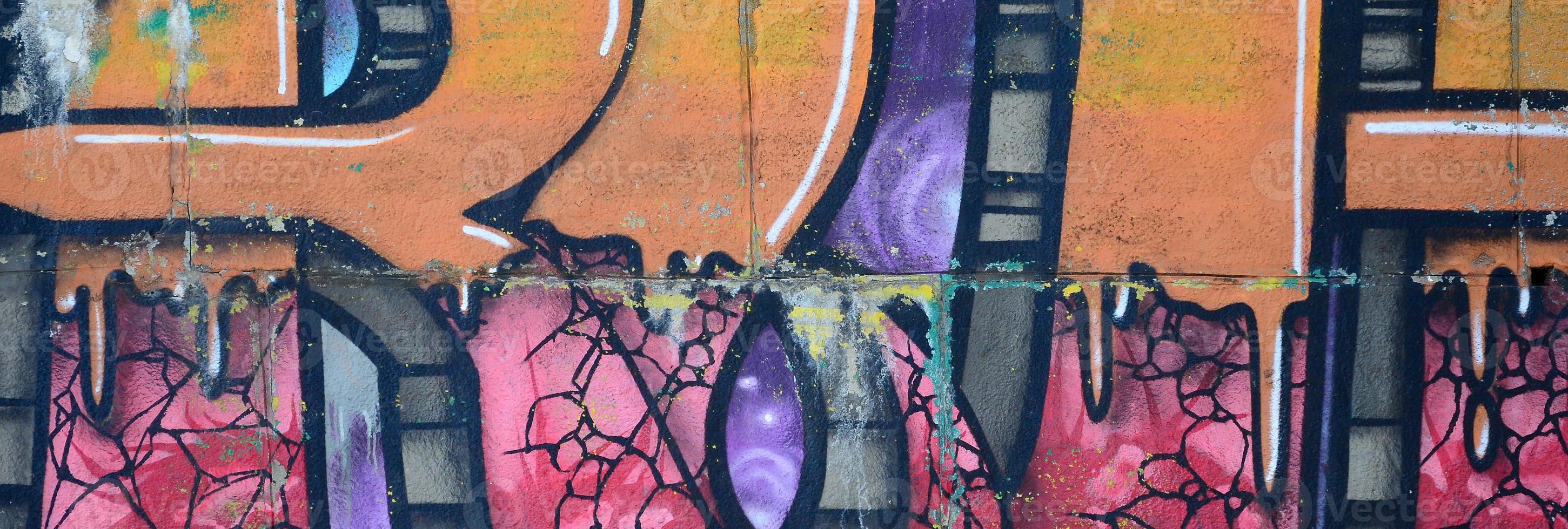 Fragment of graffiti drawings. The old wall decorated with paint stains in the style of street art culture. Colored background texture in warm tones photo