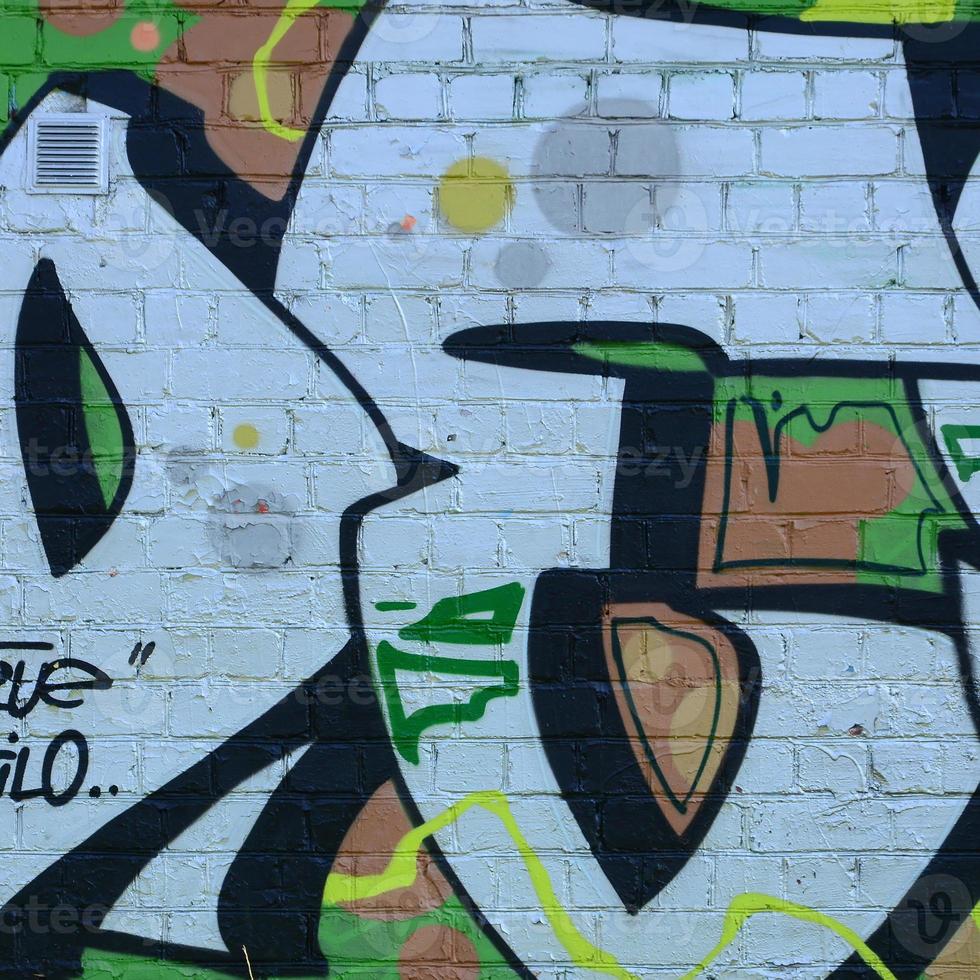 Fragment of graffiti drawings. The old wall decorated with paint stains in the style of street art culture. Colored background texture in green tones photo