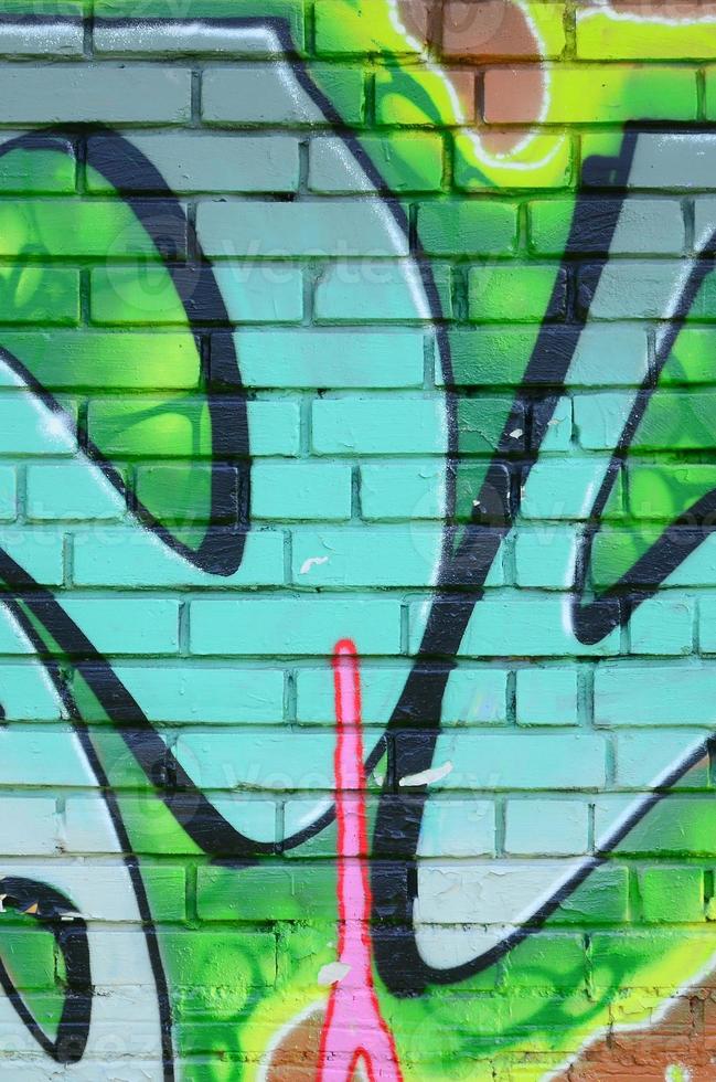 Fragment of graffiti drawings. The old wall decorated with paint stains in the style of street art culture. Colored background texture in green tones photo