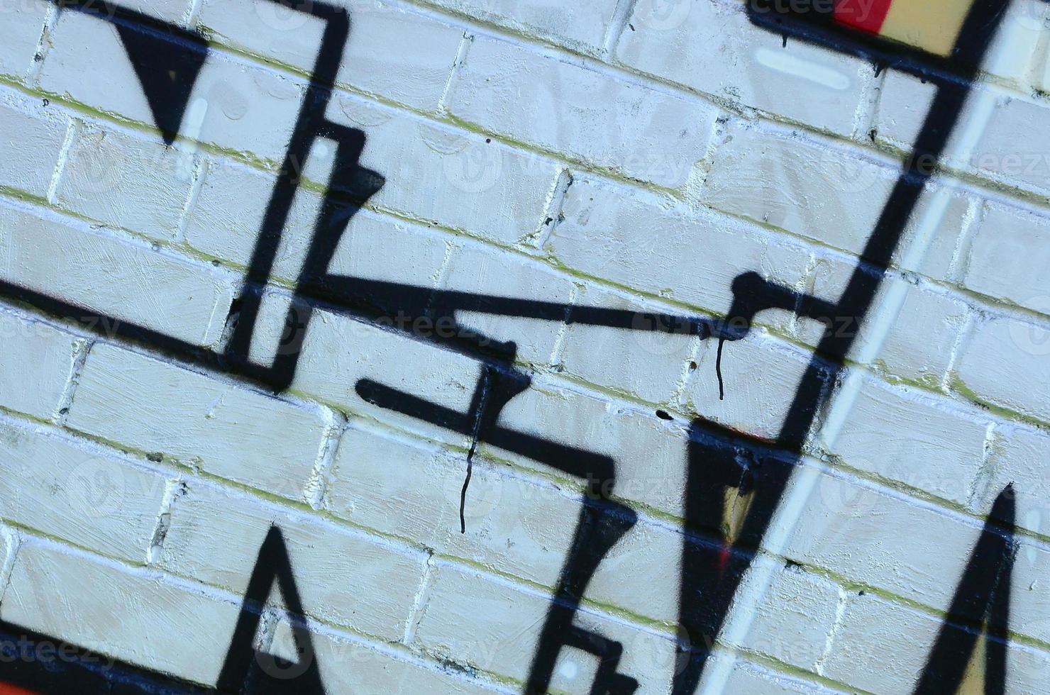 Fragment of graffiti drawings. The old wall decorated with paint stains in the style of street art culture. Colored background texture photo