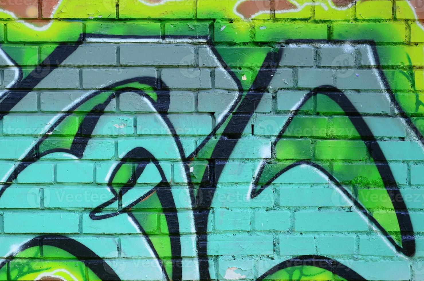 Fragment of graffiti drawings. The old wall decorated with paint stains in the style of street art culture. Colored background texture in green tones photo