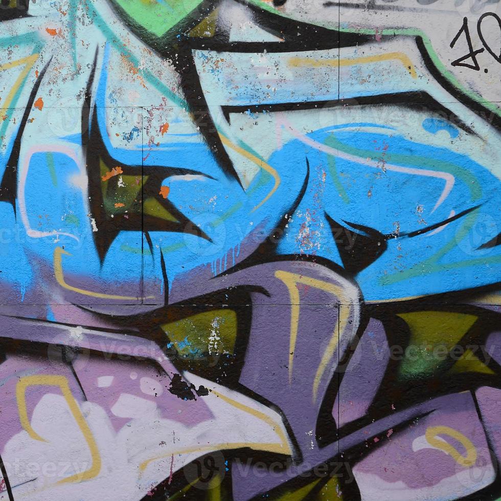 fragmento de dibujos de graffiti. la antigua muralla decorada con manchas de pintura al estilo de la cultura del arte callejero. textura de fondo coloreada en tonos fríos foto