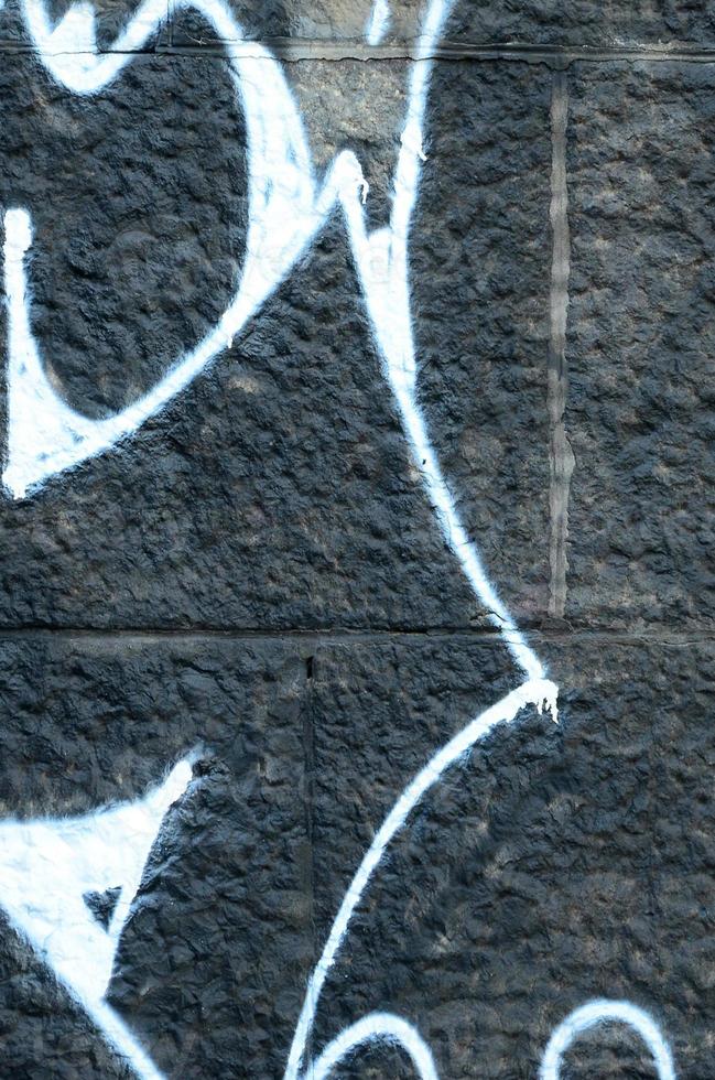 Fragment of graffiti drawings. The old wall decorated with paint stains in the style of street art culture. Colored background texture photo