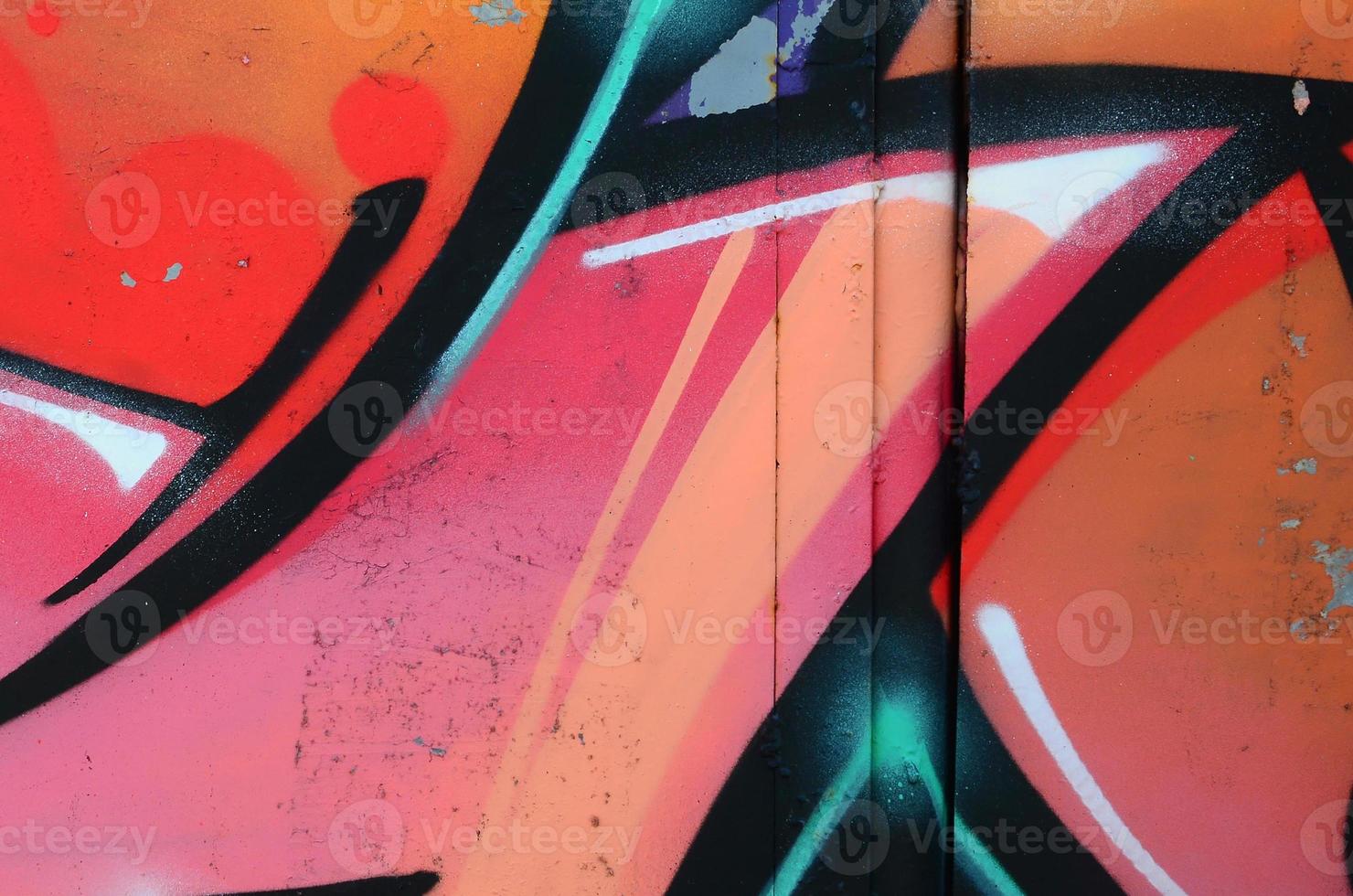 Fragment of graffiti drawings. The old wall decorated with paint stains in the style of street art culture. Colored background texture in warm tones photo