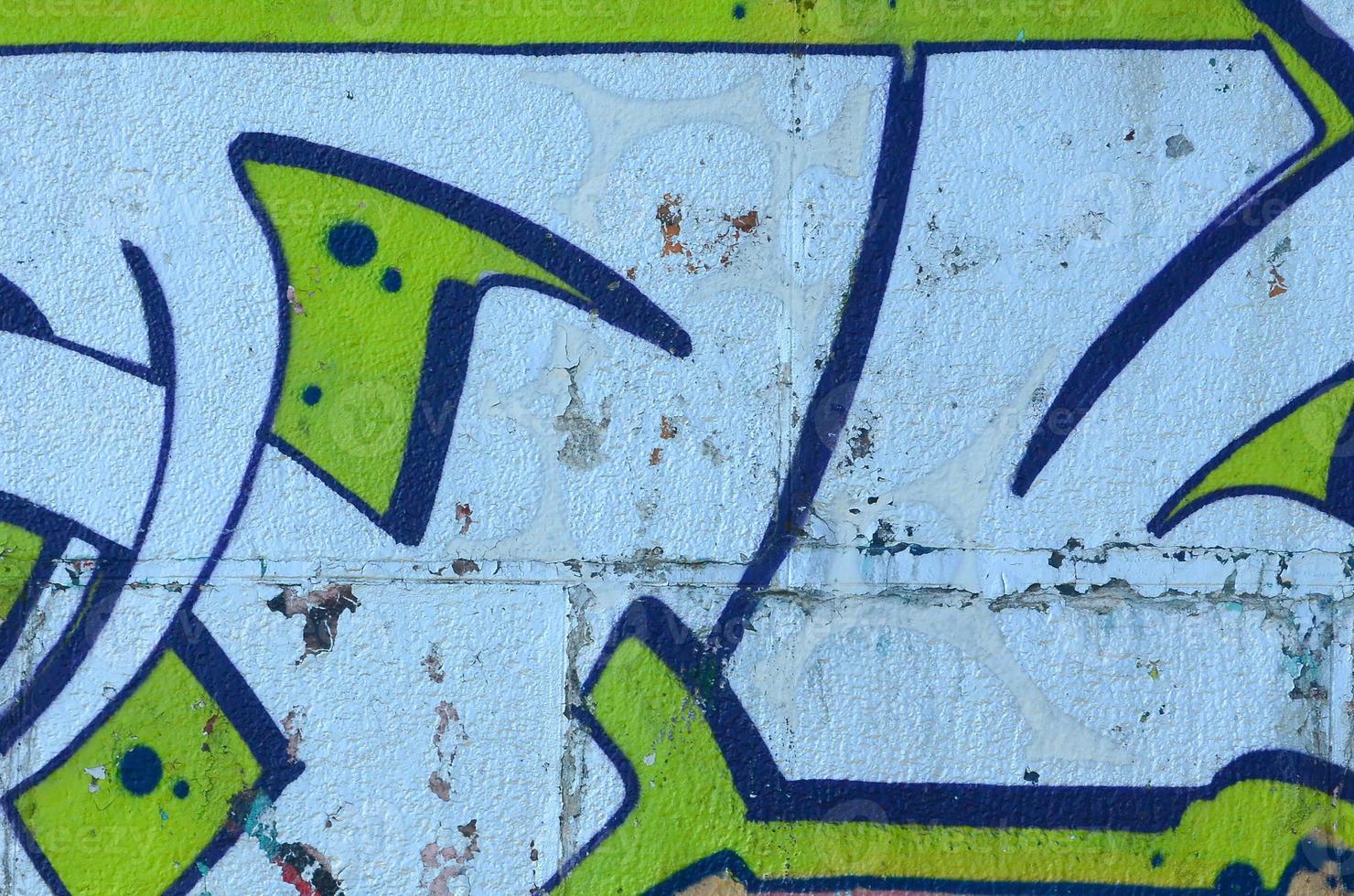 fragmento de dibujos de graffiti. la antigua muralla decorada con manchas de pintura al estilo de la cultura del arte callejero. textura de fondo coloreada en tonos verdes foto