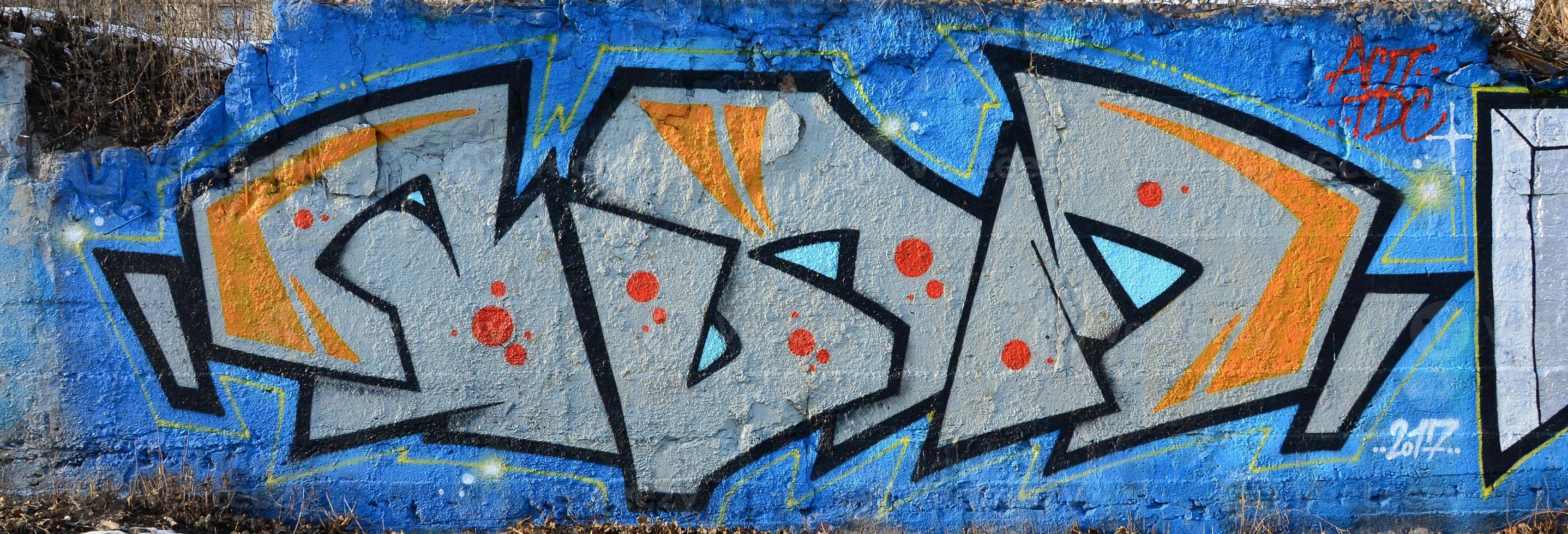 The old wall, painted in color graffiti drawing blue aerosol paints. Background image on the theme of drawing graffiti and street art photo