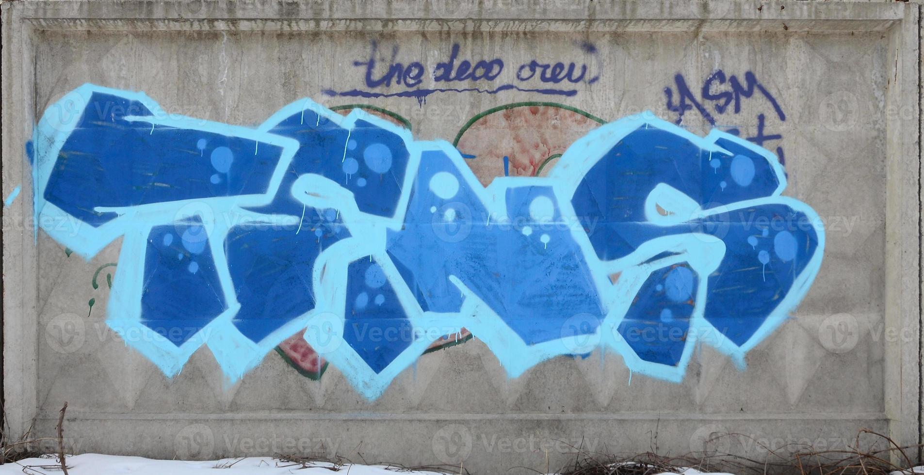 The old wall, painted in color graffiti drawing blue aerosol paints. Background image on the theme of drawing graffiti and street art photo