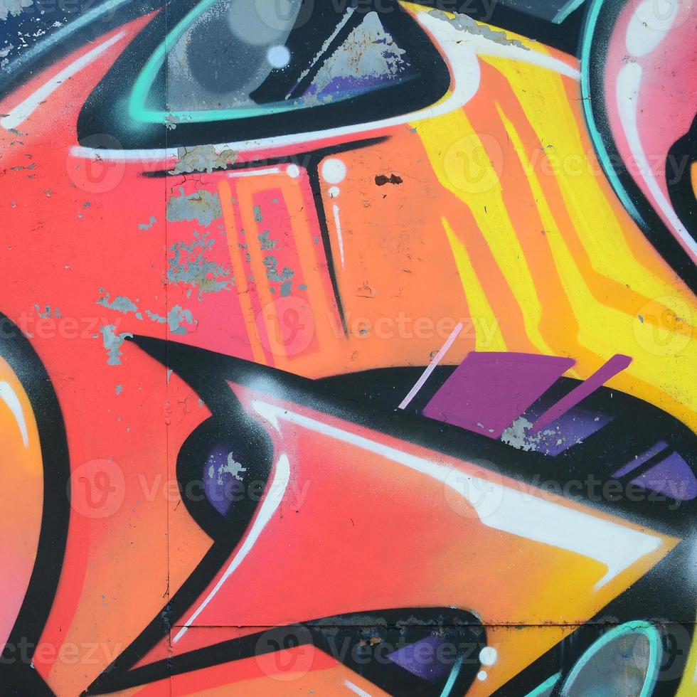 Fragment of graffiti drawings. The old wall decorated with paint stains in the style of street art culture. Colored background texture in warm tones photo