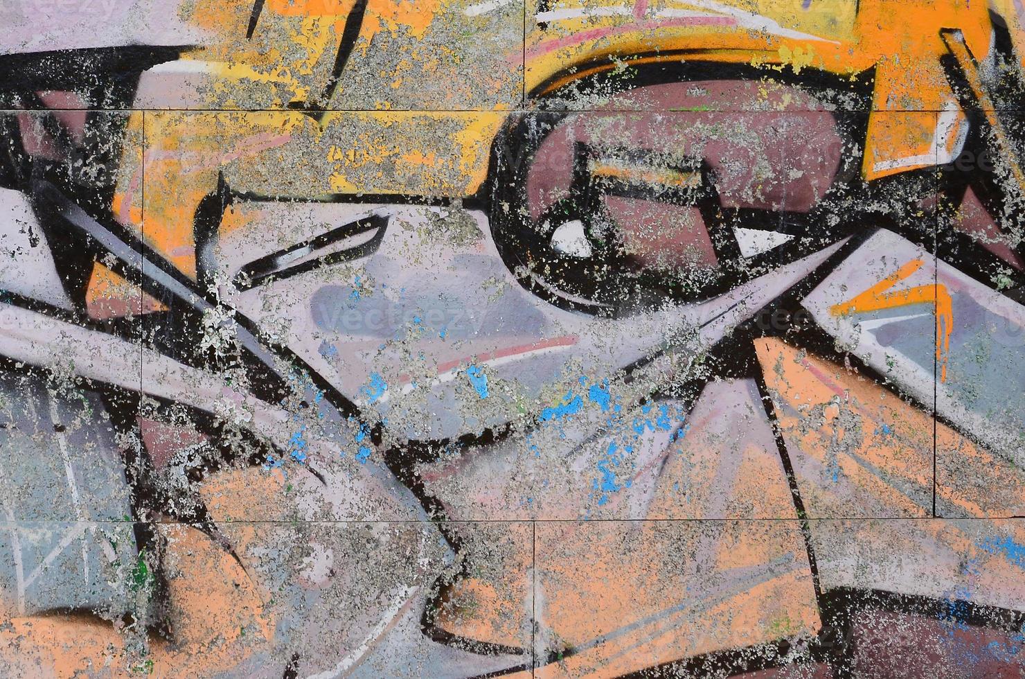 Fragment of graffiti drawings. The old wall decorated with paint stains in the style of street art culture. Colored background texture in warm tones photo