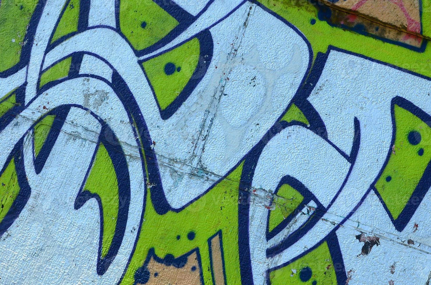 Fragment of graffiti drawings. The old wall decorated with paint stains in the style of street art culture. Colored background texture in green tones photo