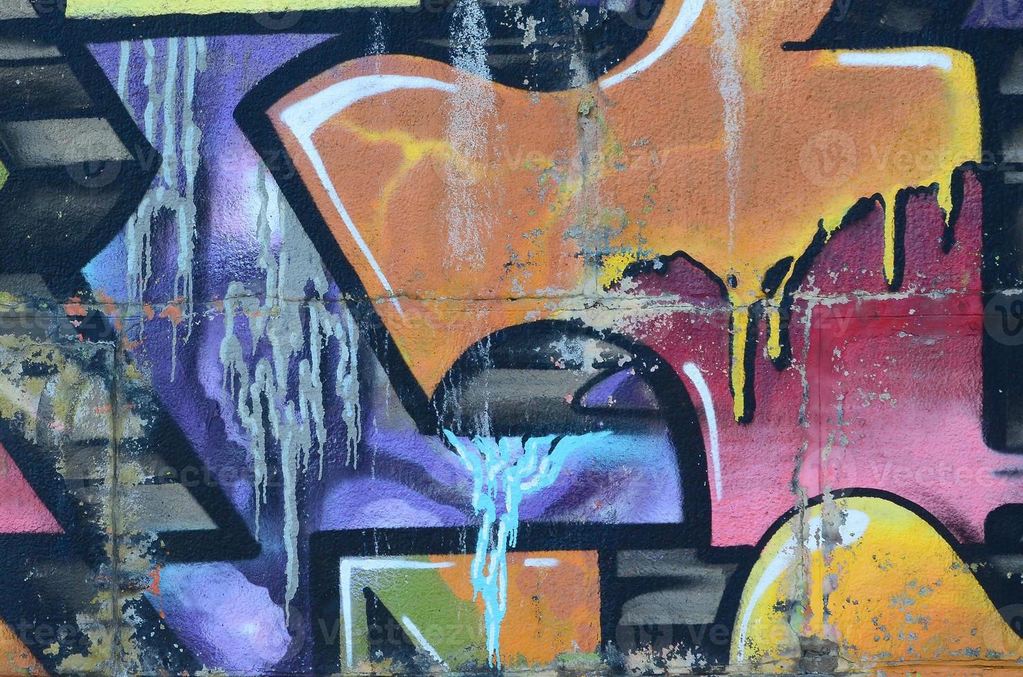 Fragment of graffiti drawings. The old wall decorated with paint stains in the style of street art culture. Colored background texture in warm tones photo