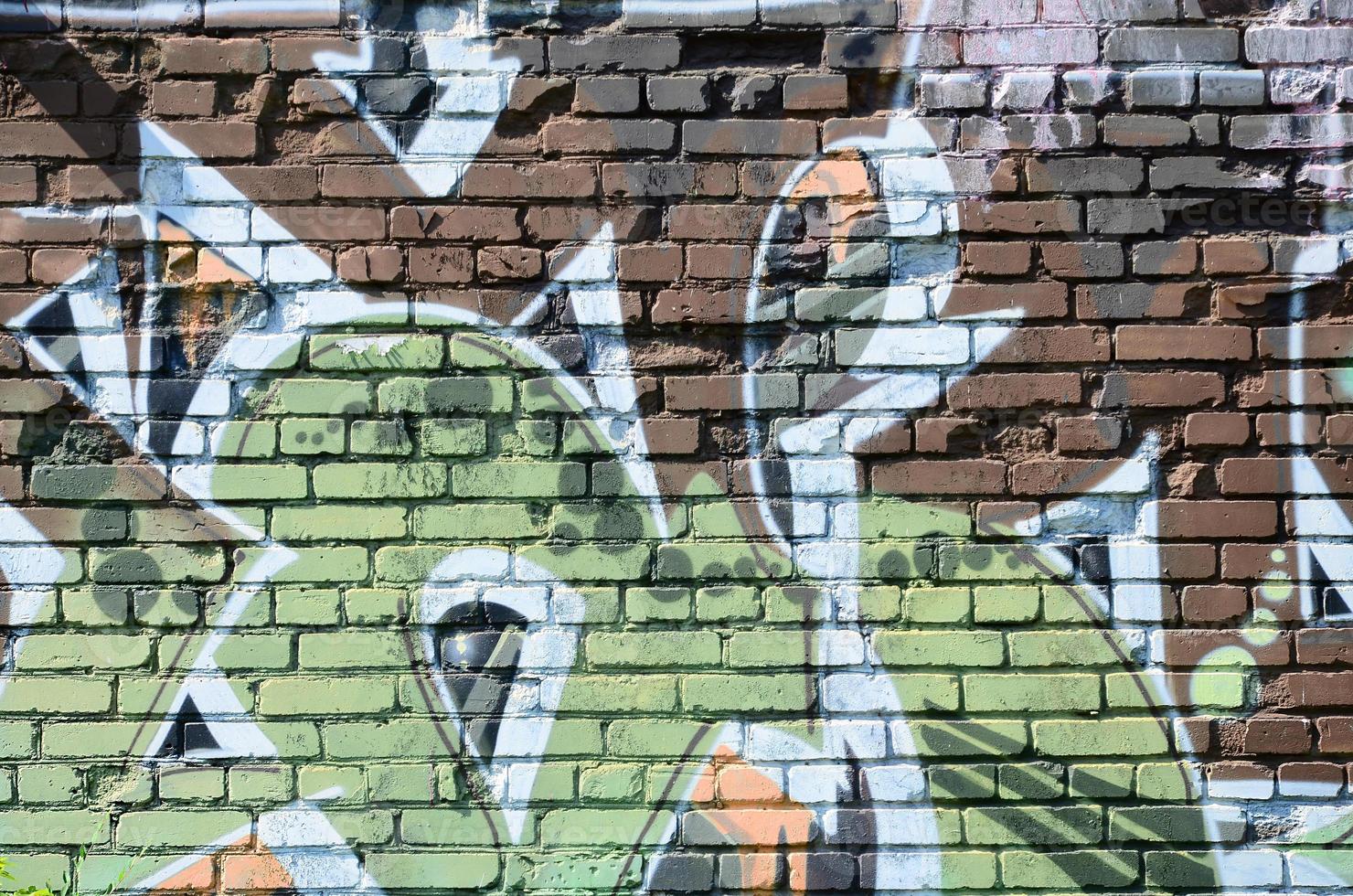 Fragment of graffiti drawings. The old wall decorated with paint stains in the style of street art culture. Colored background texture in warm tones photo