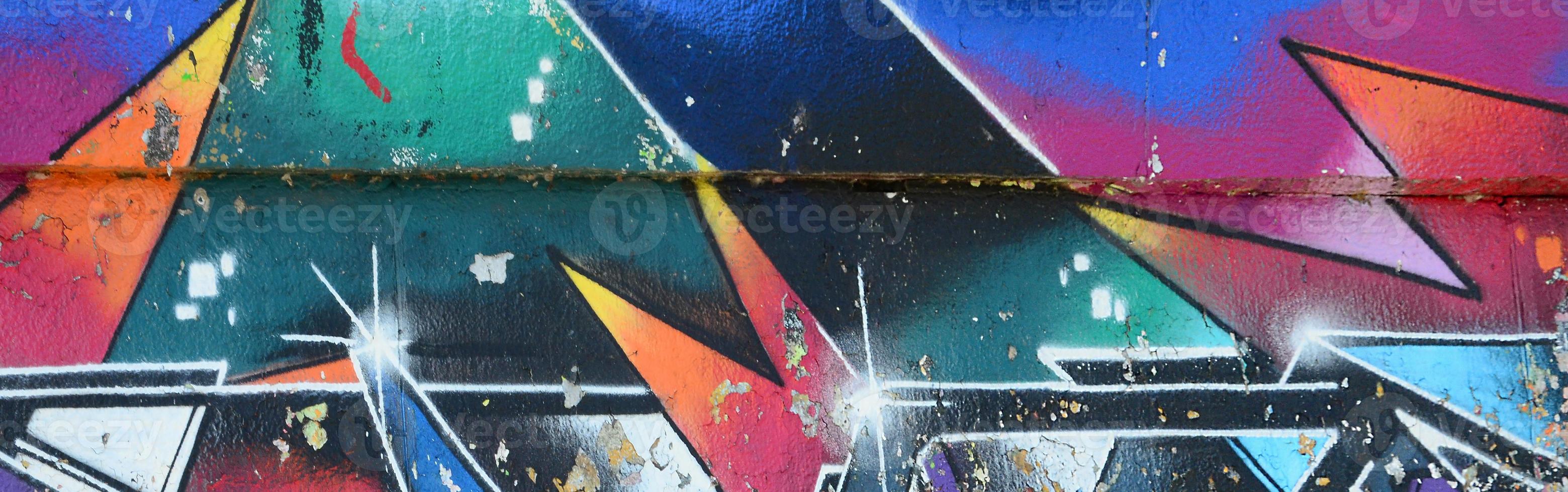 Fragment of graffiti drawings. The old wall decorated with paint stains in the style of street art culture. Multicolored background texture photo