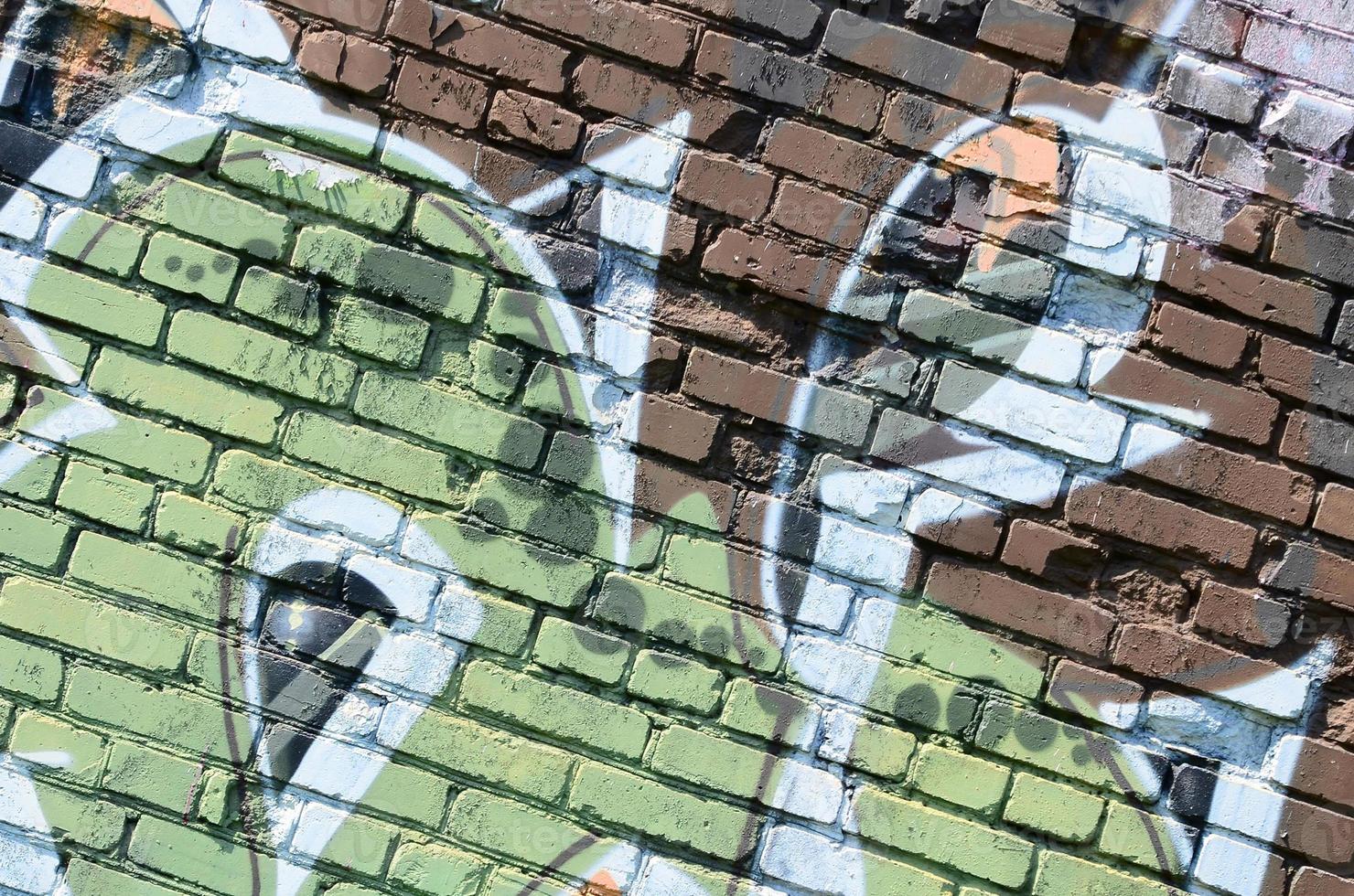 Fragment of graffiti drawings. The old wall decorated with paint stains in the style of street art culture. Colored background texture in warm tones photo