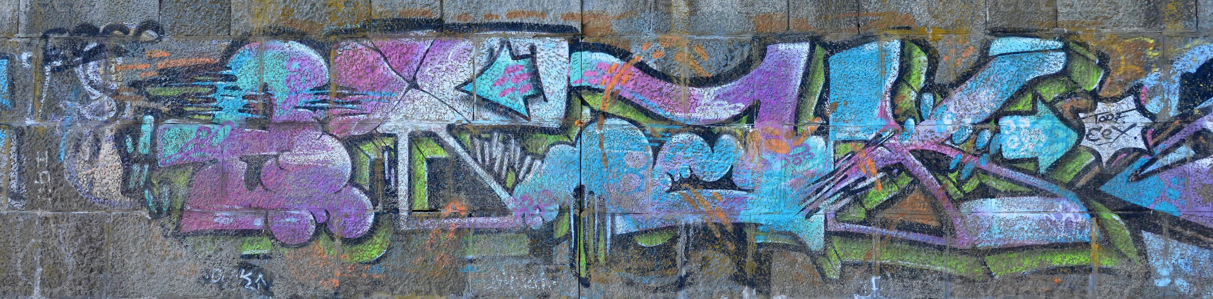Fragment of graffiti drawings. The old wall decorated with paint stains in the style of street art culture. Colored background texture in cold tones photo