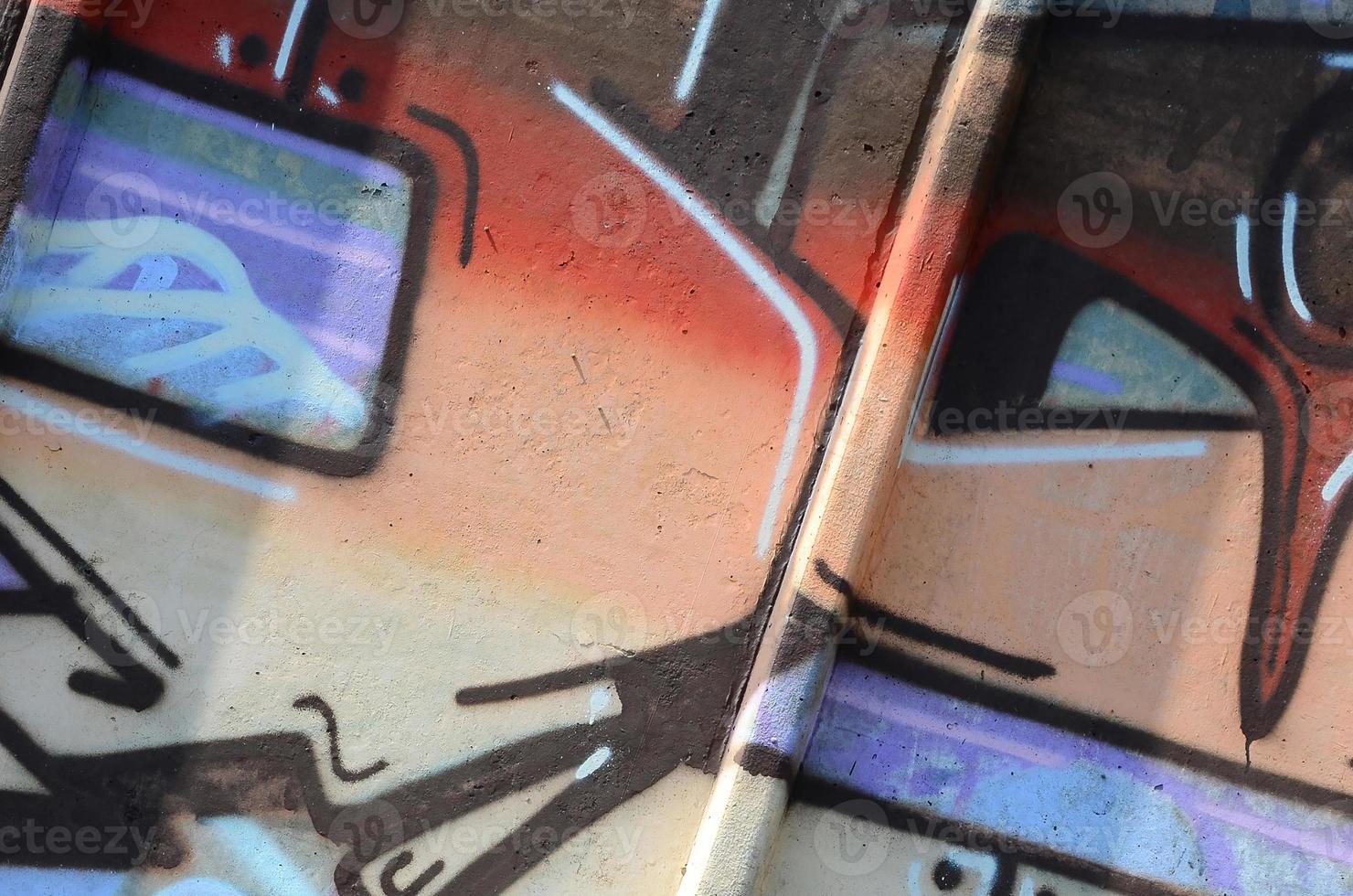 Fragment of graffiti drawings. The old wall decorated with paint stains in the style of street art culture. Colored background texture in warm tones photo