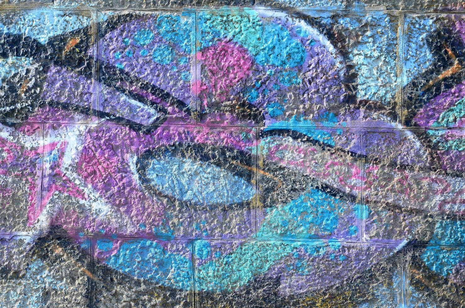 Fragment of graffiti drawings. The old wall decorated with paint stains in the style of street art culture. Colored background texture in purple tones photo