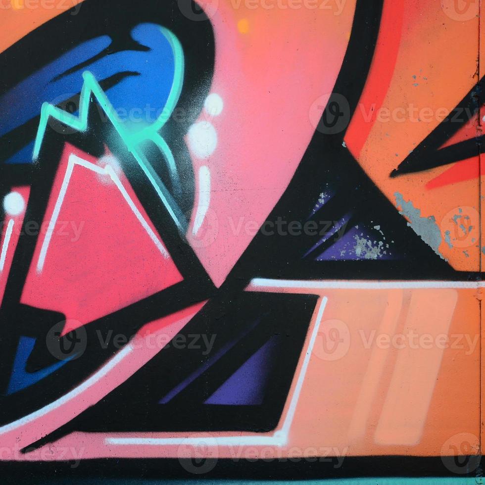 Fragment of graffiti drawings. The old wall decorated with paint stains in the style of street art culture. Colored background texture in warm tones photo