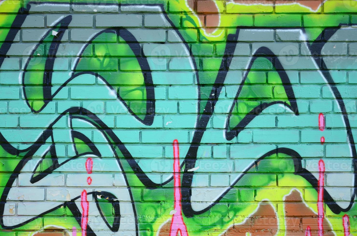 Fragment of graffiti drawings. The old wall decorated with paint stains in the style of street art culture. Colored background texture in green tones photo