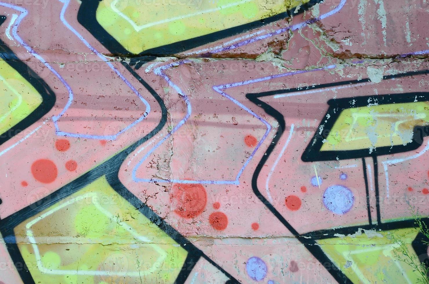 Fragment of graffiti drawings. The old wall decorated with paint stains in the style of street art culture. Colored background texture in warm tones photo