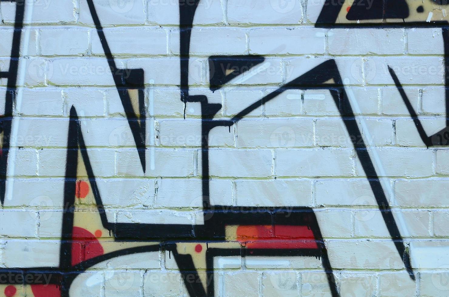 Fragment of graffiti drawings. The old wall decorated with paint stains in the style of street art culture. Colored background texture photo