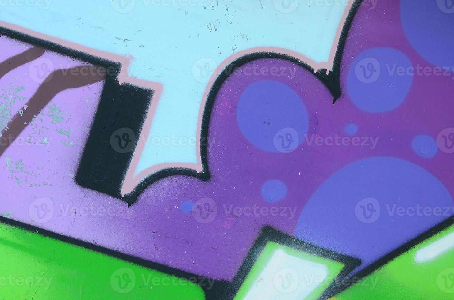 Fragment of graffiti drawings. The old wall decorated with paint stains in the style of street art culture. Multicolored background texture photo