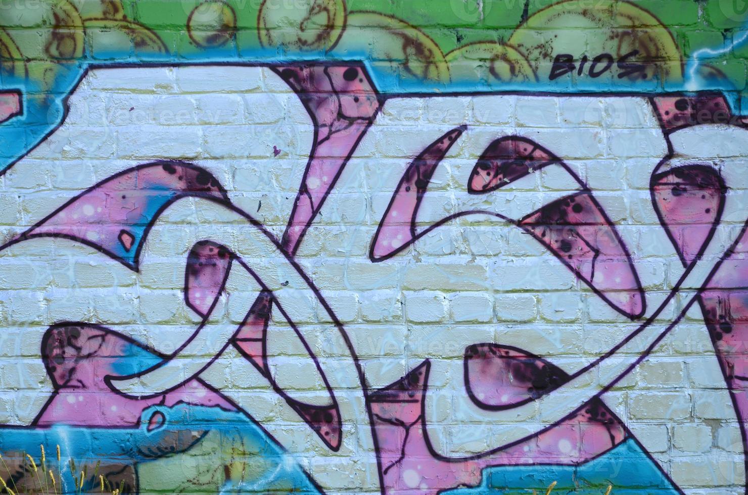 Fragment of graffiti drawings. The old wall decorated with paint stains in the style of street art culture. Colored background texture in purple tones photo