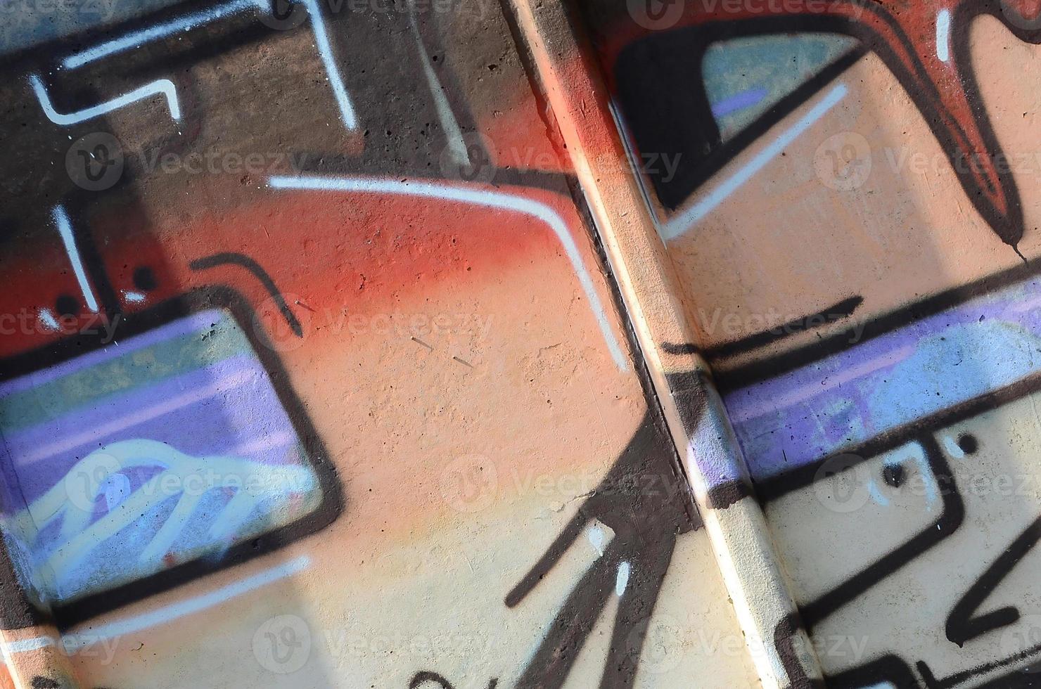 Fragment of graffiti drawings. The old wall decorated with paint stains in the style of street art culture. Colored background texture in warm tones photo