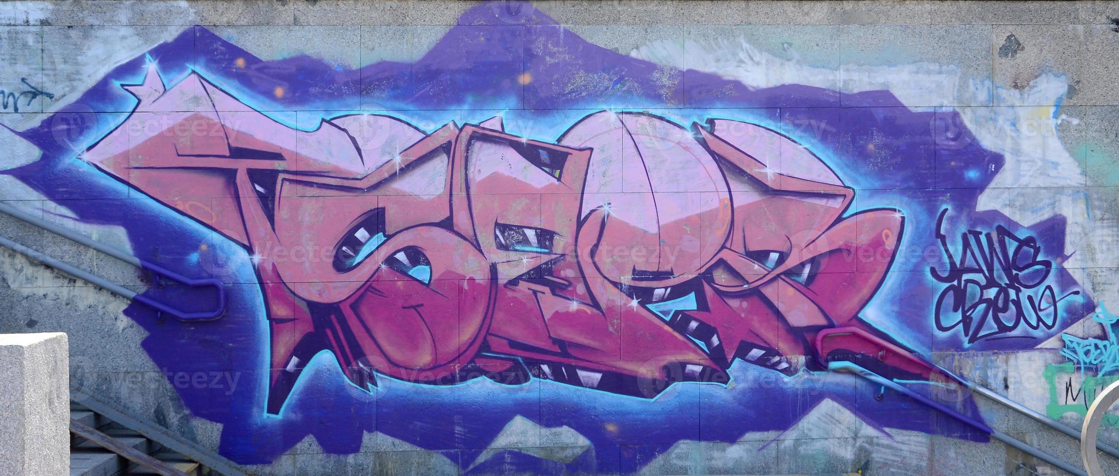 Fragment of graffiti drawings. The old wall decorated with paint stains in the style of street art culture. Colored background texture in purple tones photo