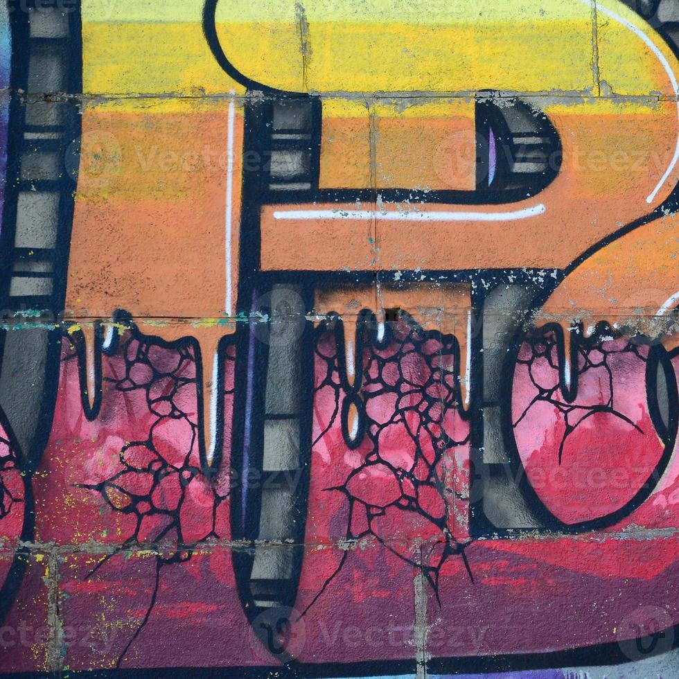Fragment of graffiti drawings. The old wall decorated with paint stains in the style of street art culture. Colored background texture in warm tones photo