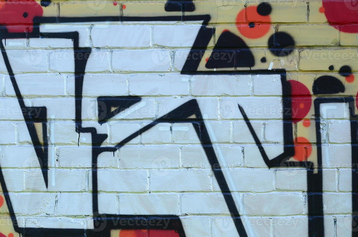 Fragment of graffiti drawings. The old wall decorated with paint stains in the style of street art culture. Colored background texture photo