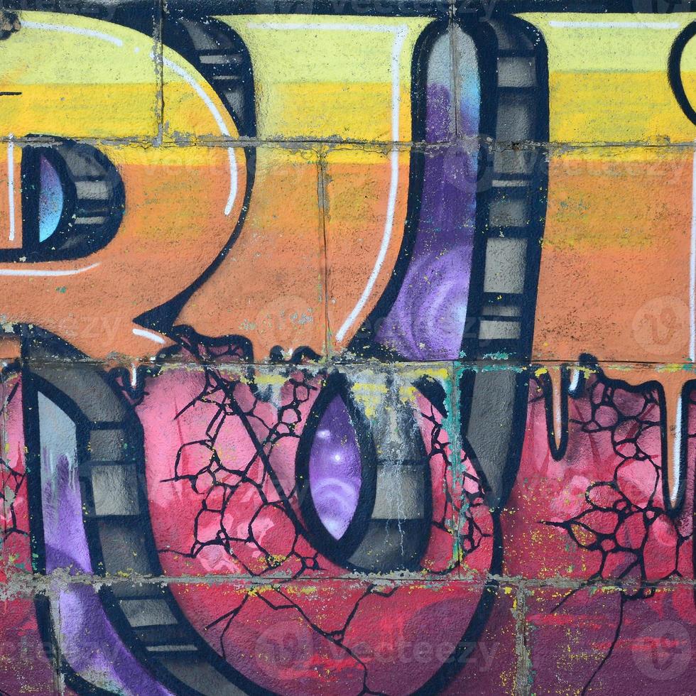 Fragment of graffiti drawings. The old wall decorated with paint stains in the style of street art culture. Colored background texture in warm tones photo