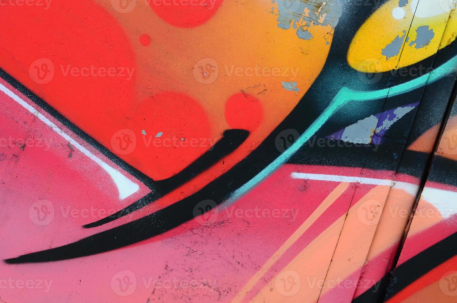 Fragment of graffiti drawings. The old wall decorated with paint stains in the style of street art culture. Colored background texture in warm tones photo