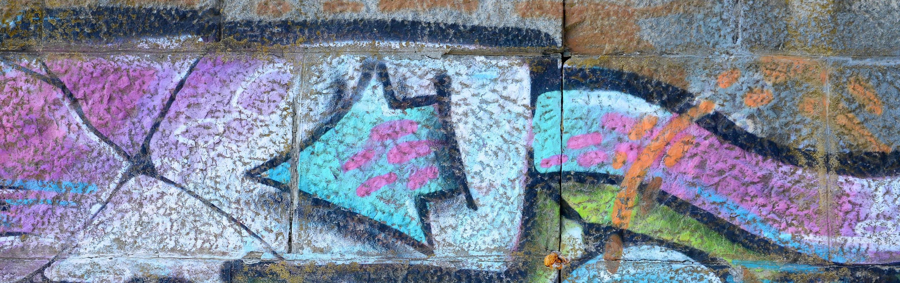 Fragment of graffiti drawings. The old wall decorated with paint stains in the style of street art culture. Colored background texture in purple tones photo